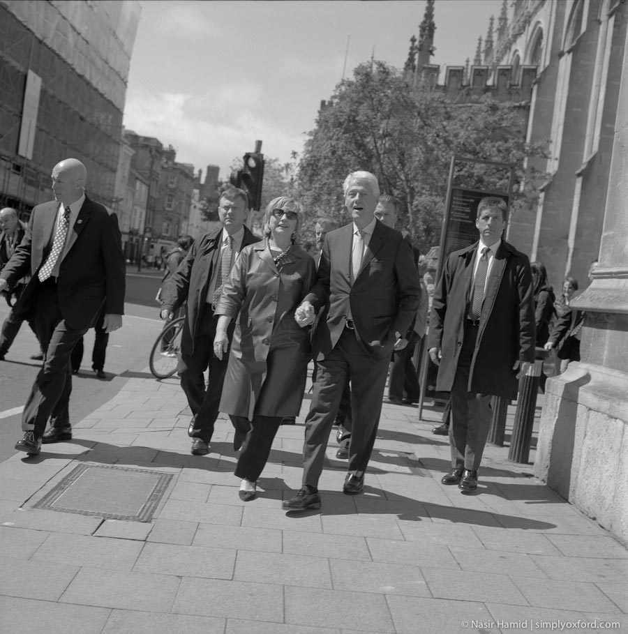 Bill and Hillary Clinton walking along Oxford High Street